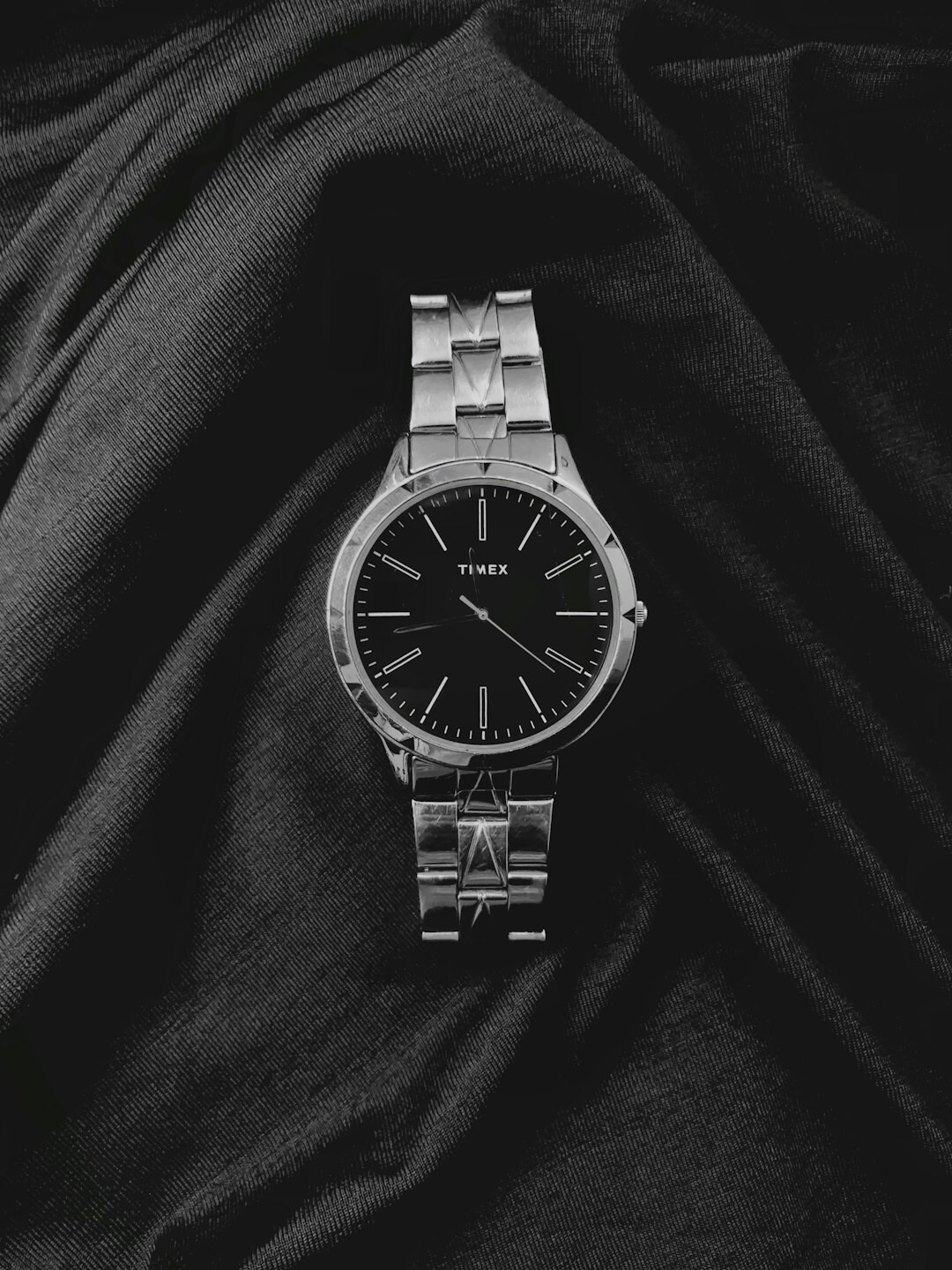 Slim gold dress watch resting on a leather desk surface