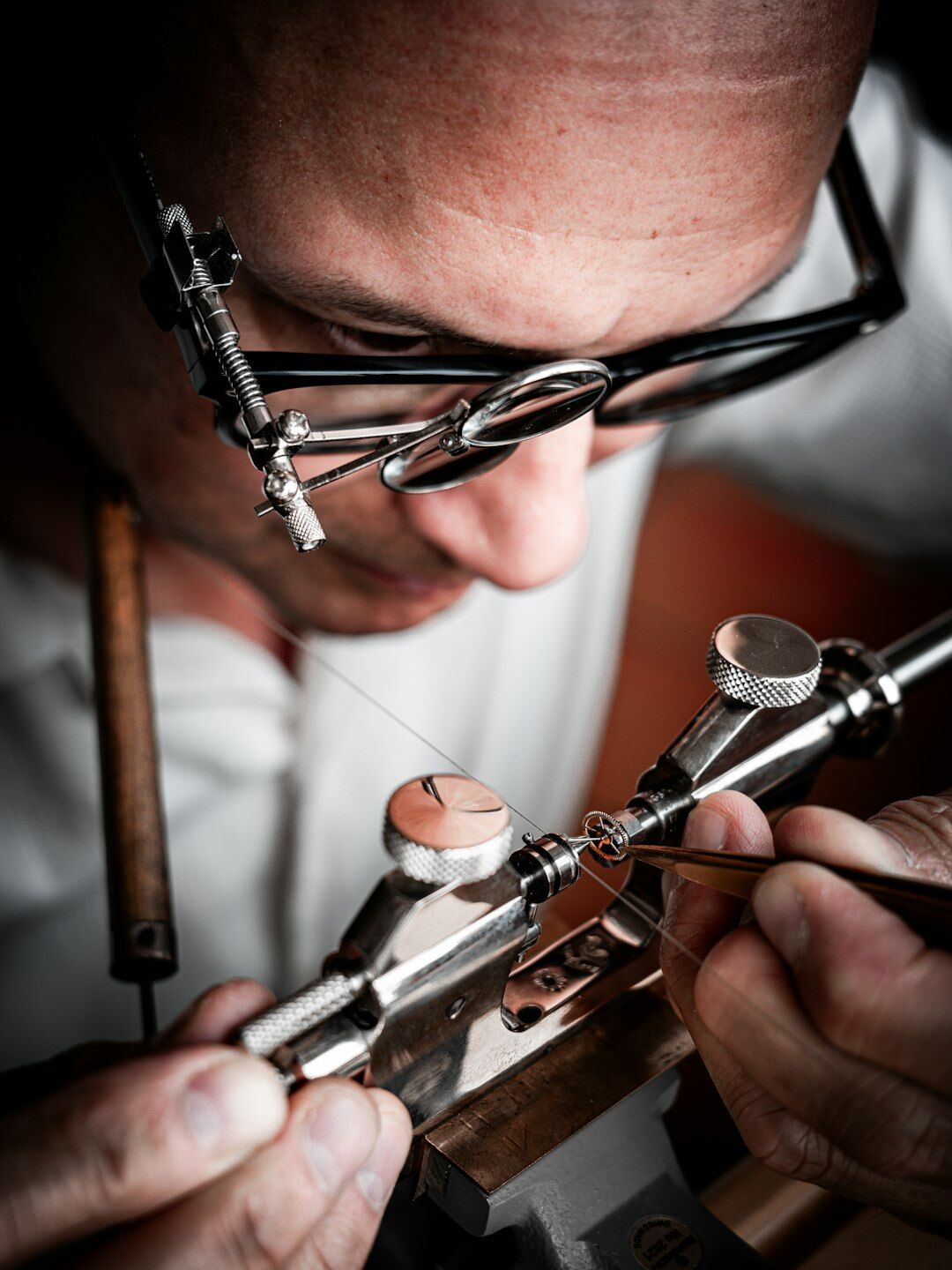 Watchmaker's hands finishing a Swiss movement with fine tools